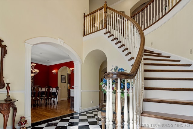 stairway featuring wood-type flooring, an inviting chandelier, and crown molding