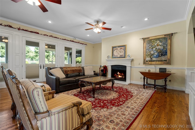 living room with dark wood-type flooring, ceiling fan, crown molding, and french doors