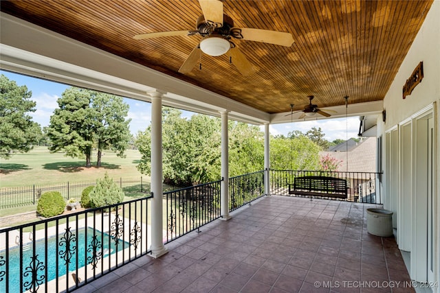 view of patio featuring a fenced in pool, ceiling fan, and a balcony