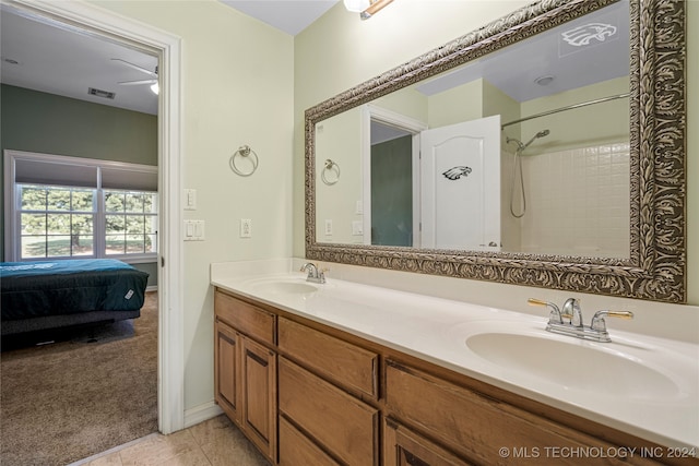 bathroom with a shower, tile patterned flooring, and vanity