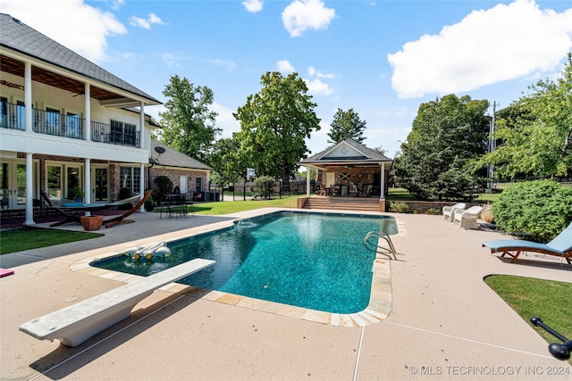 view of pool with a diving board, a gazebo, and a patio area