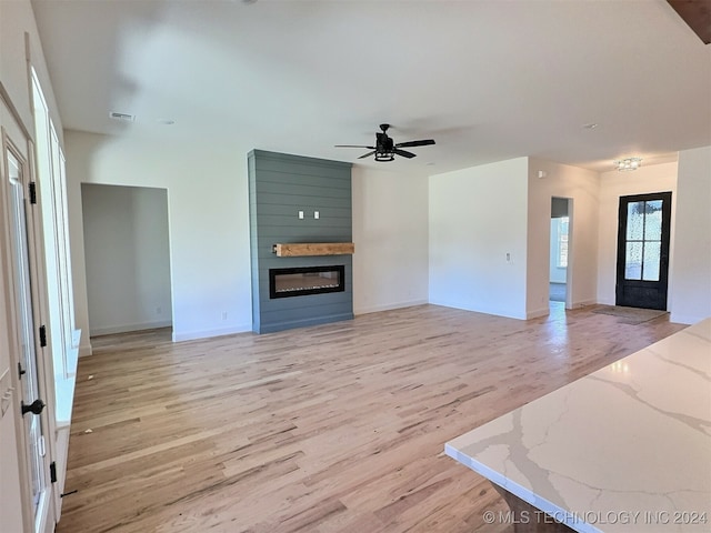 unfurnished living room featuring ceiling fan and light hardwood / wood-style flooring