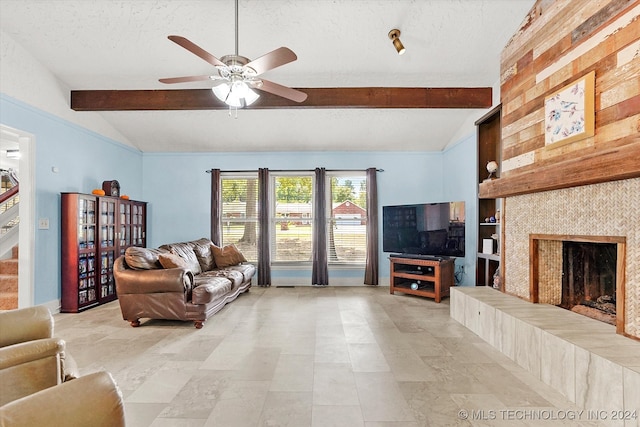 living room with a textured ceiling, ceiling fan, vaulted ceiling with beams, and a fireplace