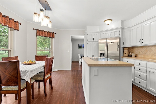 kitchen with a kitchen island, black electric cooktop, stainless steel fridge, and white cabinetry