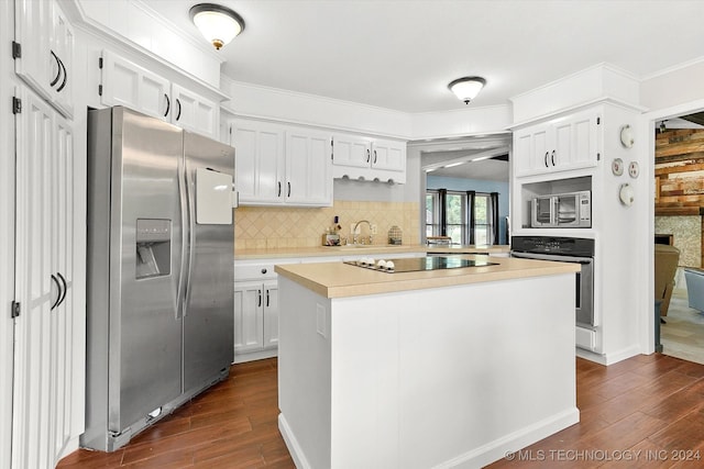 kitchen featuring crown molding, stainless steel appliances, white cabinetry, dark hardwood / wood-style floors, and a kitchen island