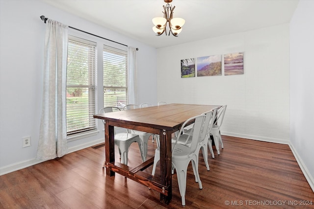 dining space with a notable chandelier and dark hardwood / wood-style flooring