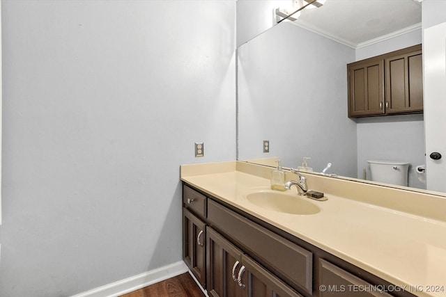 bathroom featuring crown molding, vanity, toilet, and wood-type flooring