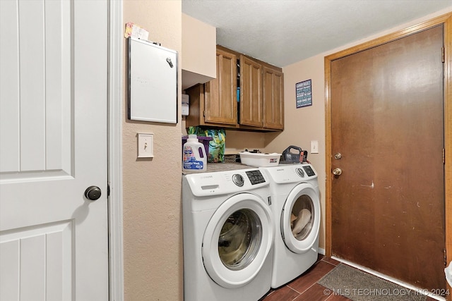 laundry area featuring dark wood-type flooring, cabinets, washer and clothes dryer, and a textured ceiling