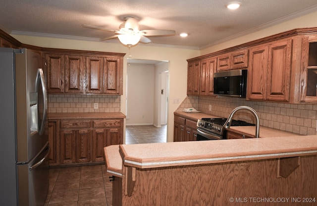 kitchen featuring kitchen peninsula, appliances with stainless steel finishes, ceiling fan, and decorative backsplash