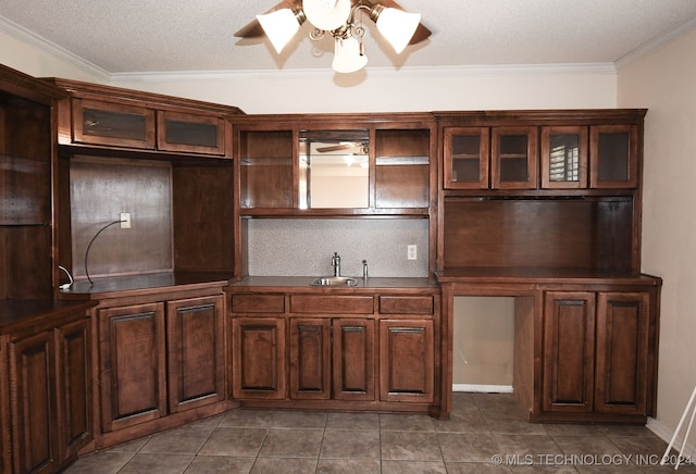 kitchen with crown molding, dark tile patterned floors, sink, and ceiling fan