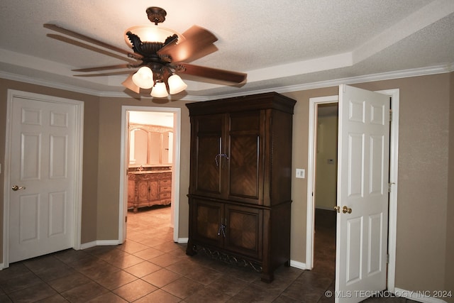 unfurnished bedroom with ornamental molding, a textured ceiling, ensuite bathroom, and ceiling fan