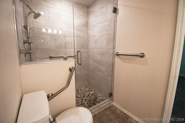 bathroom featuring tile patterned flooring, toilet, and walk in shower