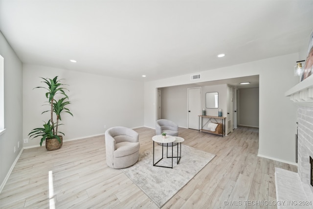 living room with a fireplace and light wood-type flooring