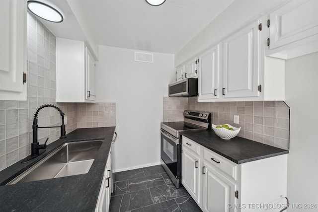 kitchen with tasteful backsplash, sink, stainless steel appliances, and white cabinets