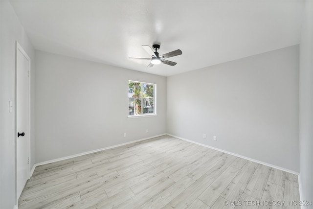 empty room with ceiling fan and light hardwood / wood-style floors