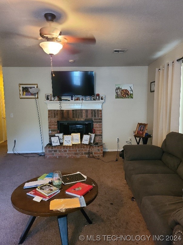 living room with ceiling fan, a brick fireplace, and carpet floors