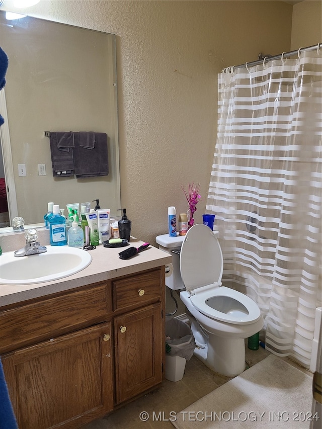 bathroom featuring vanity, toilet, walk in shower, and tile patterned floors