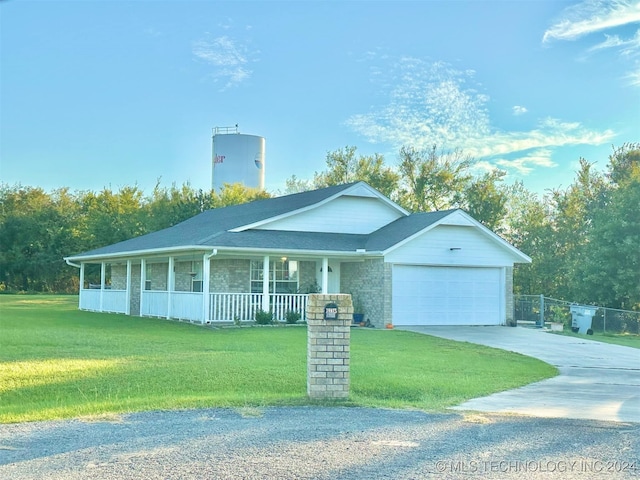 view of front of property featuring a garage, a front lawn, and covered porch