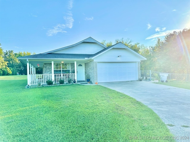 ranch-style house featuring a front yard, covered porch, and a garage