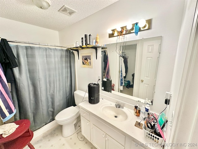 bathroom with a textured ceiling, vanity, toilet, and curtained shower