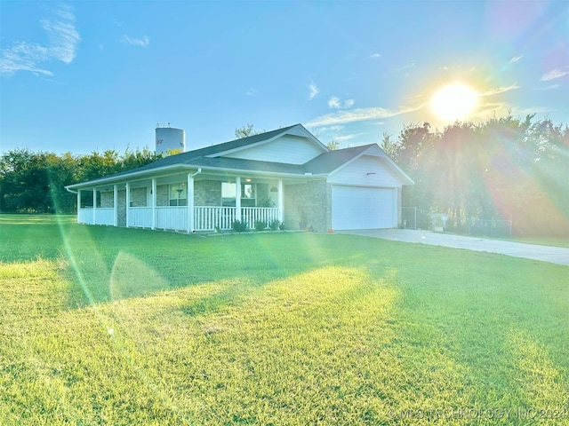 view of front of property featuring a front lawn, a garage, and covered porch