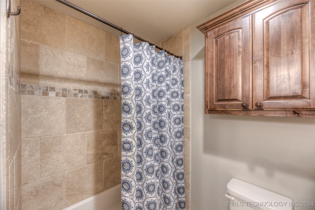 bathroom with shower / bath combo with shower curtain and toilet