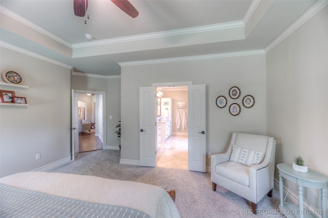 bedroom with light colored carpet, ceiling fan, ornamental molding, and a tray ceiling