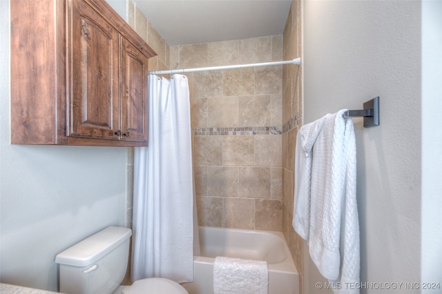 bathroom featuring shower / bath combo and toilet