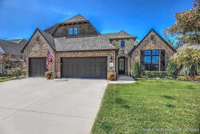 view of front facade featuring brick siding, a front lawn, concrete driveway, stone siding, and an attached garage