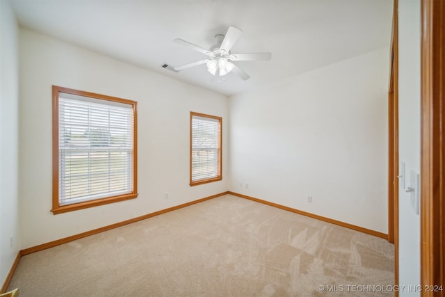 carpeted empty room featuring ceiling fan and plenty of natural light