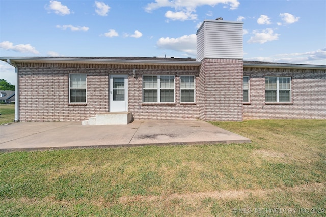 rear view of house featuring a lawn and a patio area