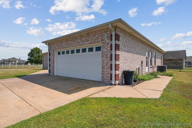 view of side of property featuring a lawn, central air condition unit, and a garage