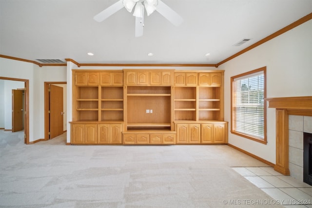 unfurnished living room featuring ornamental molding, light colored carpet, ceiling fan, and a tile fireplace