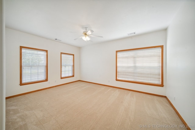 carpeted empty room featuring ceiling fan