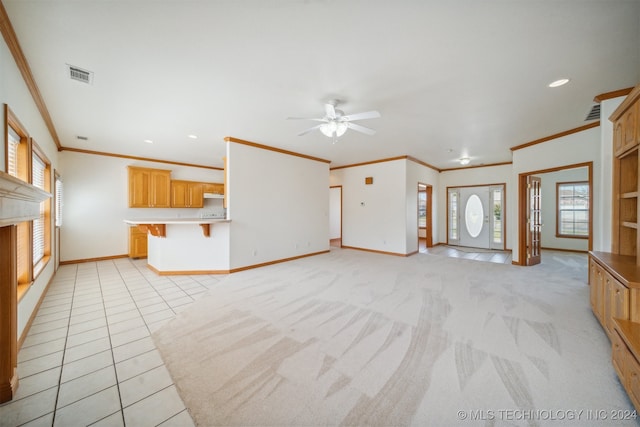 unfurnished living room featuring ceiling fan, light tile patterned floors, and ornamental molding