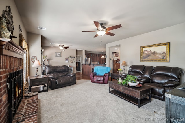 living room featuring carpet floors, a fireplace, and ceiling fan