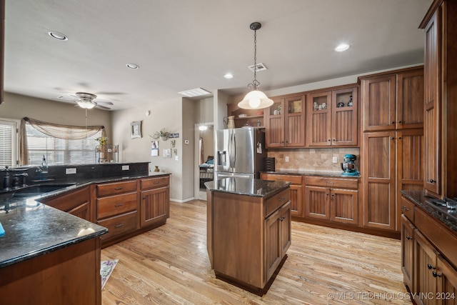 kitchen featuring light wood-type flooring, sink, stainless steel refrigerator with ice dispenser, hanging light fixtures, and ceiling fan