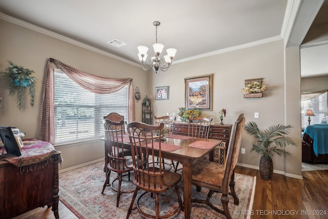 dining space featuring dark hardwood / wood-style floors, a chandelier, and crown molding