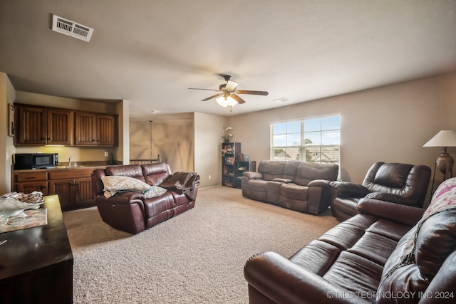 carpeted living room featuring sink and ceiling fan