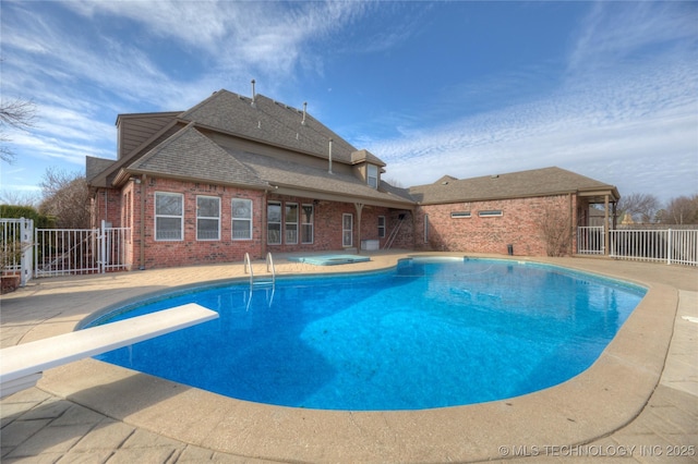 view of swimming pool featuring a fenced in pool, fence, an in ground hot tub, a patio, and a diving board