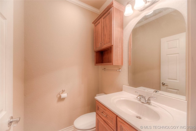 bathroom with vanity, crown molding, and toilet