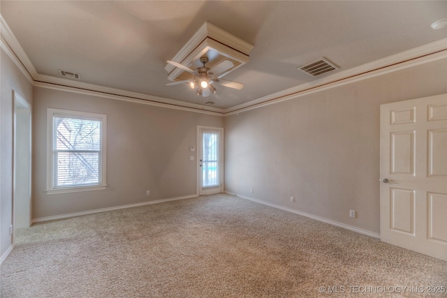 spare room with plenty of natural light, visible vents, carpet floors, and ornamental molding