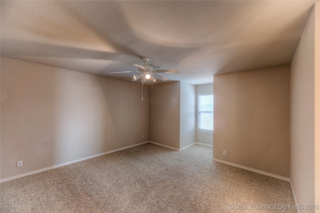 empty room with baseboards, light carpet, a textured ceiling, and a ceiling fan