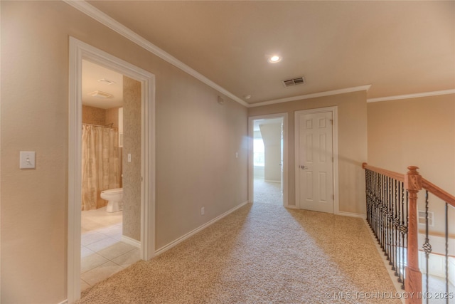 hall featuring visible vents, baseboards, carpet, and ornamental molding