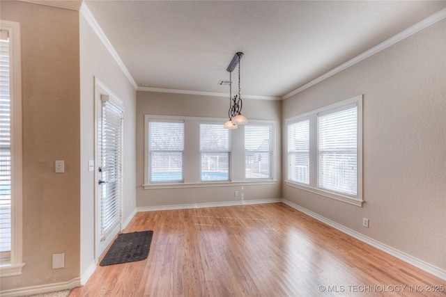 unfurnished dining area with visible vents, baseboards, wood finished floors, and crown molding