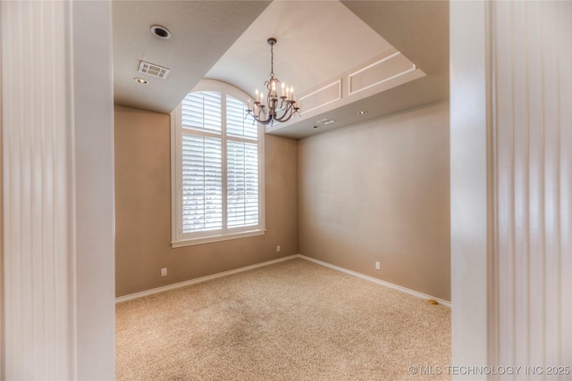 empty room featuring visible vents, baseboards, carpet, and an inviting chandelier