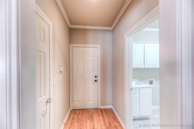 hallway with baseboards, light wood-style floors, and crown molding