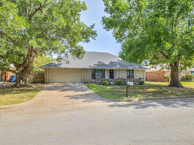 ranch-style house with a garage and a front lawn