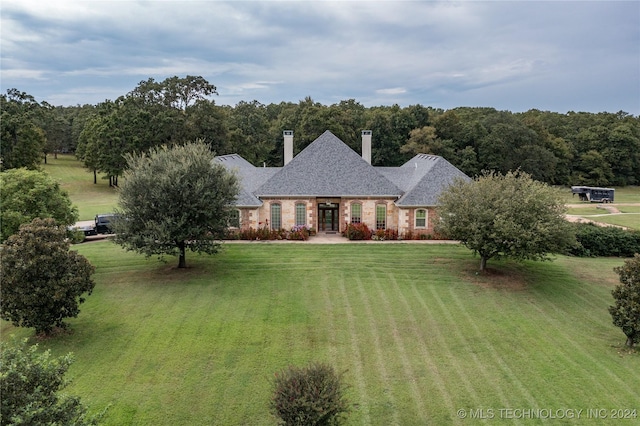 view of front of house with a chimney and a front yard