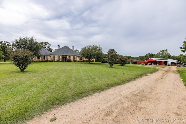 view of front of home featuring a front lawn, driveway, and a chimney